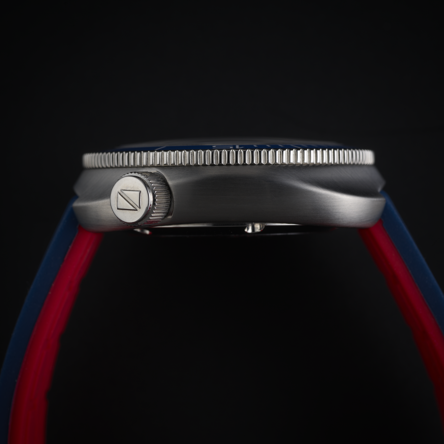 Close-up of a Ligure Founders Edition GMT LWT21007 watch with a red and blue strap on a black background